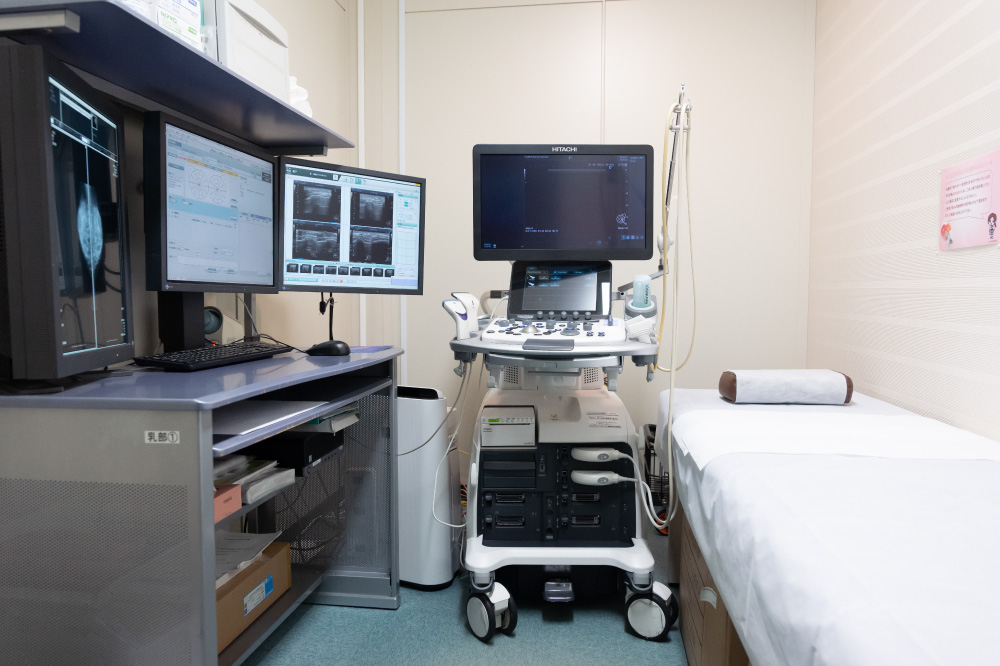 超音波検査機器と診察用ベッドのある部屋